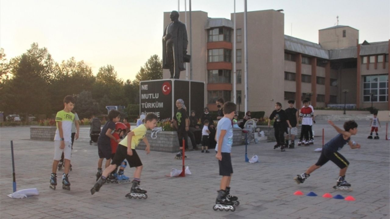 Sıcak asfaltta paten süren çocuklar kışın kayak yapmaya hazırlanıyor